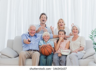 Extended Family Watching The Television On Couch