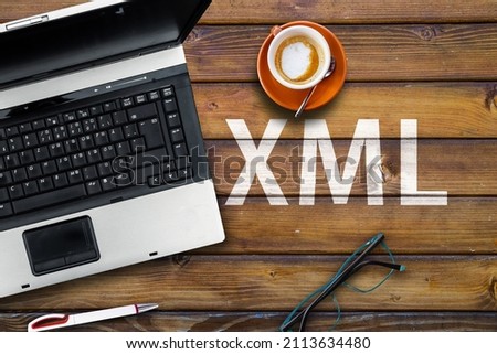 Extensible Markup Language. Word XML on wooden desk with laptop