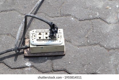 The Extension Power Strip, Power Cord Old And Damaged On The Construction Site Outdoor. Extremely Dangerous, Not Safe If In Use. Should Be Replaced. Unsafe Workplace