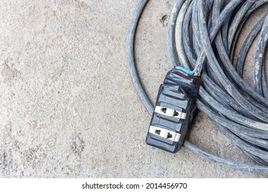 The Extension Power Strip, Power Cord Old And Damaged On The Construction Site Outdoor. Extremely Dangerous, Not Safe If In Use. Should Be Replaced. Unsafe Workplace