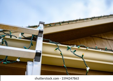 Extension Step Ladder Against Side Of Roof With A Strand Of Christmas Lights
