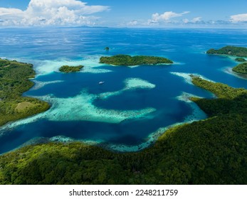 Extensive coral reefs fringe rainforest-covered islands in the Solomon Islands. This beautiful country is home to spectacular marine biodiversity and many historic WWII sites. - Shutterstock ID 2248211759