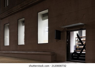 Exterior Of The Beauty Salon With Big Windows And Glass Door In The Old Building In Europe. Entrance Of The Modern Barbershop In The Evening.