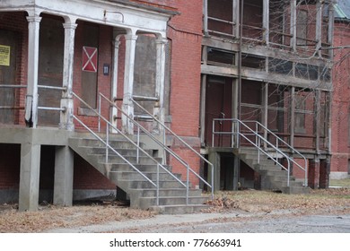 Exterior of boarded up and abandoned brick asylum hospital building 