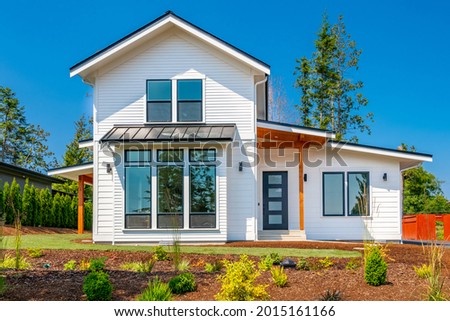 Exterior of brand new construction home with white pain black trim and rich blue skies