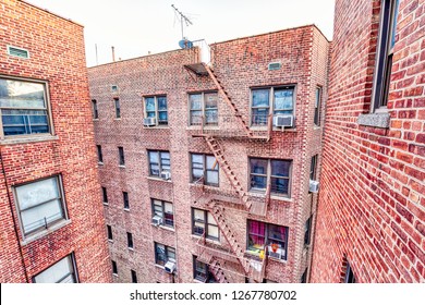 Exterior Of Brick Apartment Condo Building With Roof In Fordham Heights, Bronx, New York City With Fire Escapes Ladders, Windows, Ac Units, Satellite Dish And Antenna