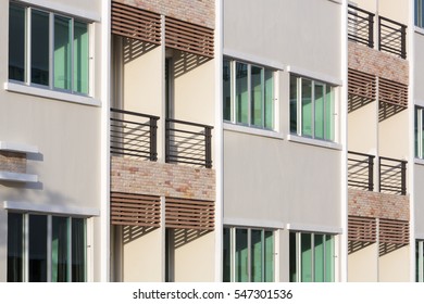 Exterior Of  Of  Cheap Apartment Building With Green Windows.