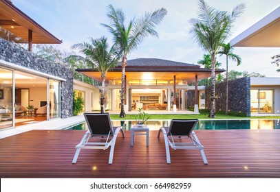 Exterior Design Of Spacious Modern Luxury Pool Villa. Feature Wooden Decking, Sunbed, Big Swimming Pool And Greenery Garden  Home, House , Building , Hotel, Resort