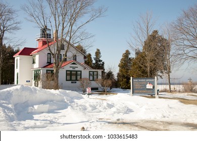 Exterior Of Historic Grand Traverse Lighthouse In Traverse City On Traverse Bay, Michigan Along Shores Of Frozen Lake Michigan In Winter.