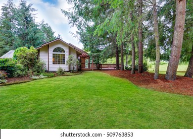Exterior of horse ranch with french windows, green grass and fir trees around. Northwest, USA
