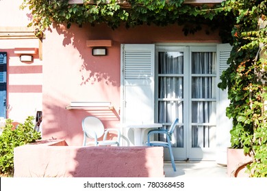 Exterior Of House Hotel Room Chairs Table White Door Balcony Terrace Plants Pink Wall Cosy Morning Design Pastel Colors