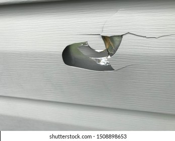 Exterior House Vinyl Siding Damage Showing Hole