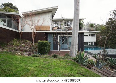Exterior Of A Large Mid Century Modern Australian Home With Pool And Landscaped Garden