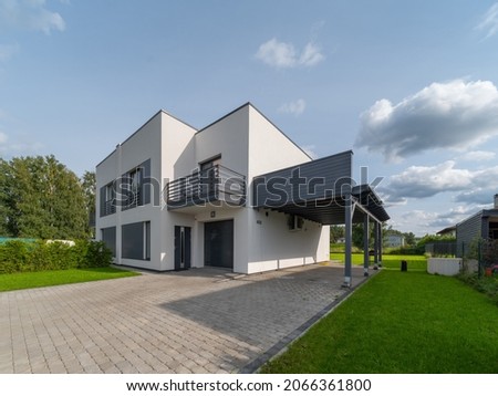 Exterior of modern luxury private house. Garage entrance. Canopy. Blue sky. Sunny day.