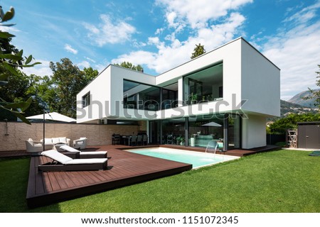Exterior modern white villa with pool and garden, nobody inside