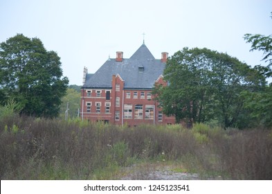 Exterior Of Old Abandoned Brick Mental Hospital Asylum Overgrown With Ivy 