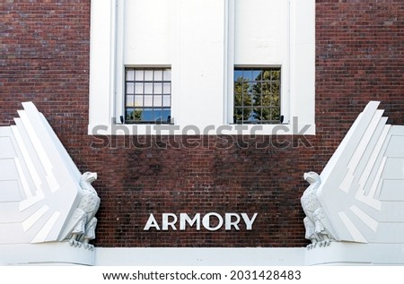 Exterior of old vintage armory building with art deco white eagles on a brick building.