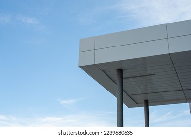 The exterior overhang of a contemporary commercial style building with aluminum metal composite panels and glass windows. The futuristic building has engineered diagonal cladding steel frame panels.