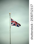 Exterior photo view of a national emblem flag floating at the wind on a flagpole pole pillar of the country UK united kingdom great britain british brits english england king queen symbolic icon air
