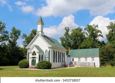 Exterior of Pretty Little White Country Church on a Sunny Day with White clouds