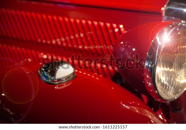 exterior of a red retro car with a radiator\
heater fragment, mudguard and head\
lamp