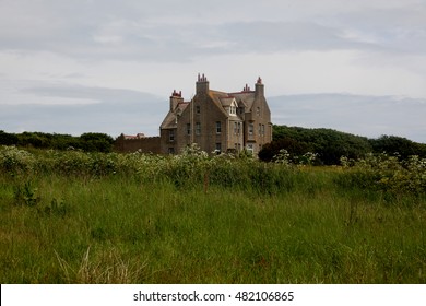 Exterior Shot Of An Old Isolated House In An Overgrown Field In The Northern Scottish Highlands.