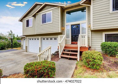 Exterior Of Two Story Clapboard Siding House With Three Garage Spaces And Driveway. Northwest, USA