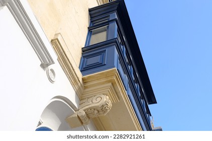 Exterior typical maltese houses   colorful wooden balconies  beautiful limestone buildings  Bottom up view the blue wooden balcony and stucco 