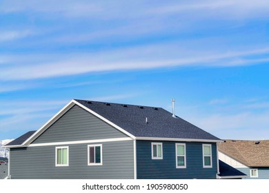 Exterior of upper floor of home with gable roof and gray horizontal wood wall
