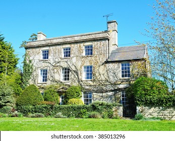 Exterior View Of A Beautiful Old English House On A Lush Village Green