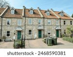 Exterior view of beautiful old terraced stone cottage houses on a street in a typical English town - architecture and travel themed photograph in colour 