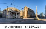 Exterior view of the curved building of the central library of Manchester in UK with people walking on the St Peters Square .