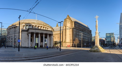 Exterior view of the curved building of the central library of Manchester in UK with people walking on the St Peters Square .
