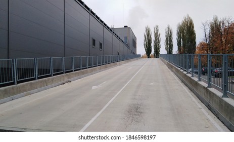 Exterior View Of An Empty Supermarket Parking Lot With Only One Car In The Center. Shopping Carts Are Assembled On The Side Of The Square.