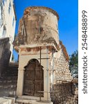 Exterior view of the Fortified Tower of Hydra, a significant historical landmark on Hydra Island, Greece, known for its defensive role. It is situated directly opposite the Kountouriotis Mansion.