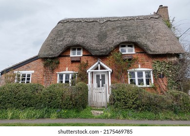 Exterior View And Front Door Of A Beautiful Old Thatched Cottage House On A Street In An English Town