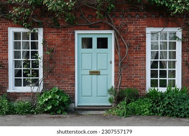 Exterior view, front door and garden of a beautiful old red brick town house on a street in an English city - Powered by Shutterstock