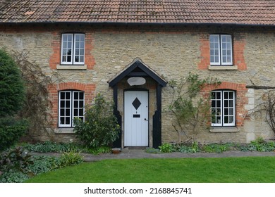 Exterior View And Garden Of A Beautiful Old Cottage House On A Street In An English Town