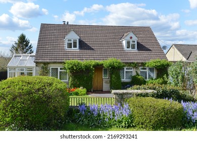 Exterior View And Garden Of A Beautiful Old Cottage House On A Street In An English Town