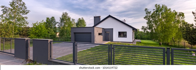 Exterior view of a house with fence and garage, panorama