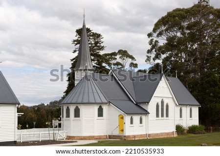 Exterior view of Huon Anglican Church, beautiful timber church with yellow timber doors and cemetary located behind, located near the township of Huonville