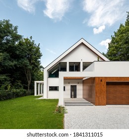 Exterior View Of Stylish And Modern House With Cobblestone To Doors And Green Lawn