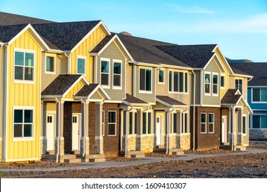 Exterior view of townhomes with gable roof stairs and square columns at entrance