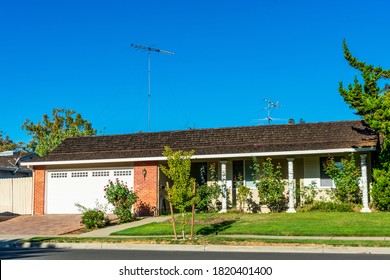 Exterior View Of Traditional Ranch Style Single Family Detached Home With A Long, Low-rising Roof In An Older Established Residential Neighborhood.