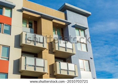 Exterior view of typical new multifamily mid-rise residential building with balconies. The buildings usually rental apartments, college dorms, condominiums, or assisted-living facilities