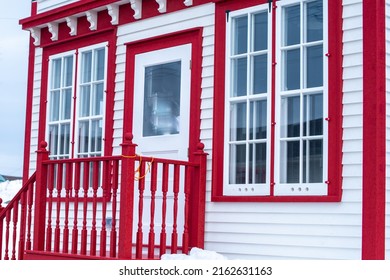 The Exterior Of A Vintage Convenience Store With Multiple Large Glass Windows, A White Wooden Door With A Glass Window, And Decorative Moldings And Trim. The Door Has A Wooden Handrail And Step.