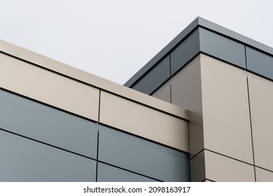 The exterior wall of a contemporary commercial style building with aluminum metal composite panels and glass windows. The futuristic building has engineered diagonal cladding steel frame panels. - Shutterstock ID 2098163917
