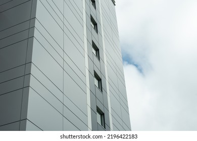 The exterior wall of a contemporary commercial style building with aluminum metal composite panels and glass windows. The futuristic building has engineered diagonal cladding steel frame panels. - Shutterstock ID 2196422183