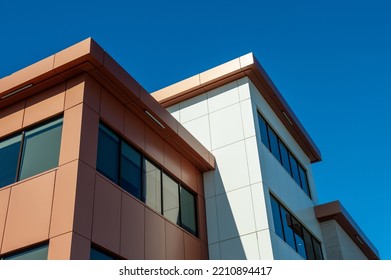 The exterior wall of a contemporary commercial style building with aluminum metal composite panels and glass windows. The futuristic building has engineered diagonal cladding steel frame panels.  - Powered by Shutterstock