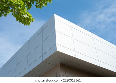 The exterior wall of a contemporary commercial style building with aluminum metal composite panels and glass windows. The futuristic building has engineered diagonal cladding steel frame panels.  - Shutterstock ID 2220312361